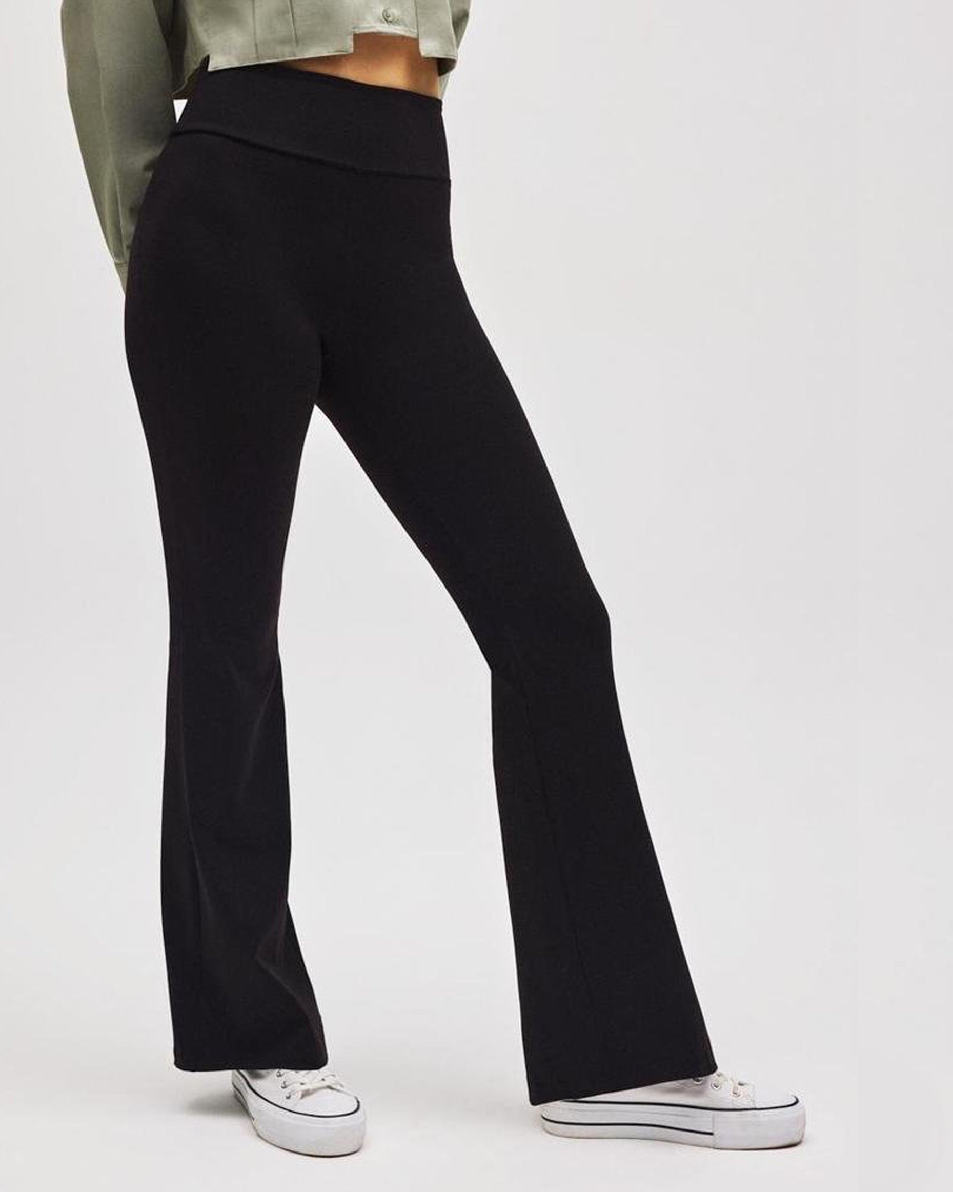 Black flared pants worn by a person on a white background