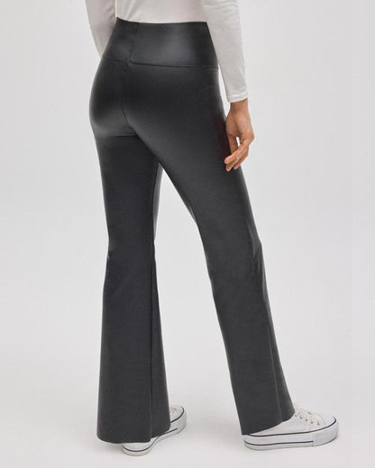 Black faux leather flared pants worn by a person on a white background, back view.