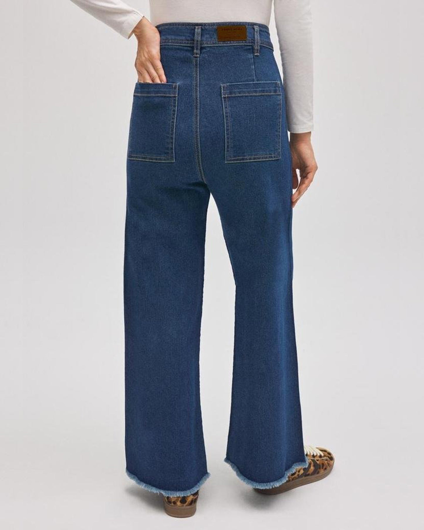 Blue jeans worn by a person on a white background