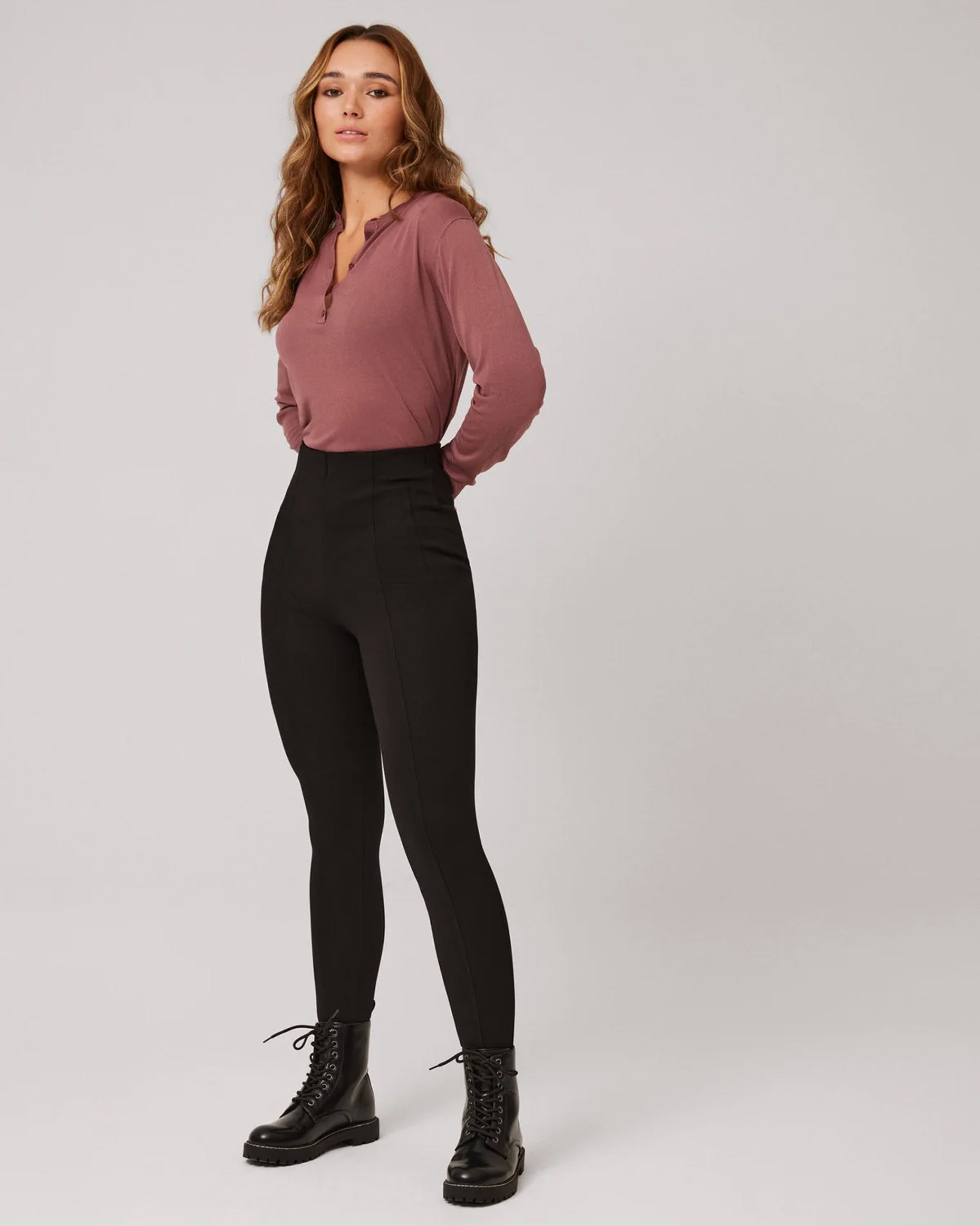 Ysabel Mora 70290 High Rise Treggings - Black high waisted trouser leggings (treggings) with shaped darted waist and centre seams down the front of the leg, worn with black lace up boots and dirty pink long sleeve top.
