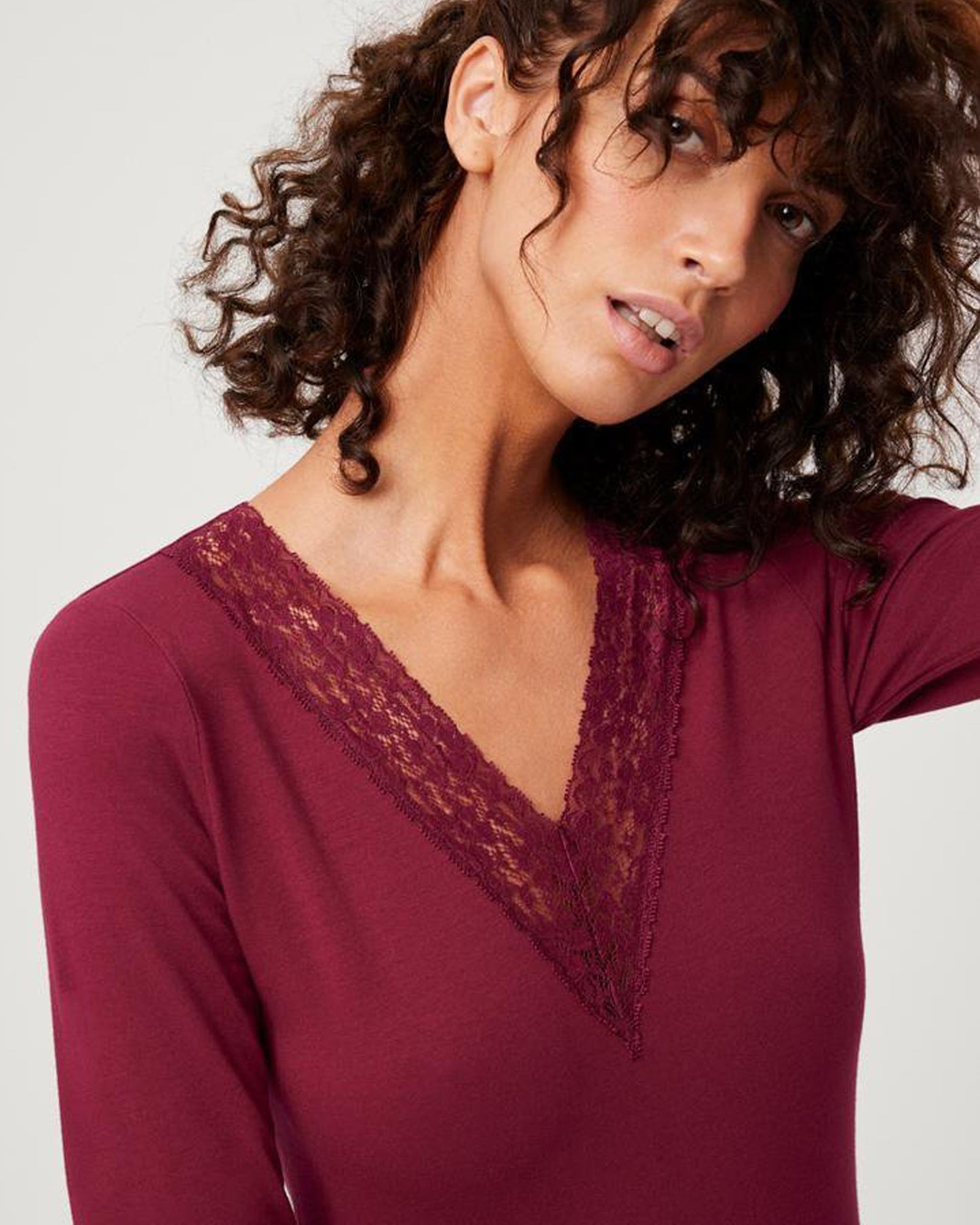 Soft and light long sleeved wine vest top with a floral lace trim v-neck and lace trim cuffs.