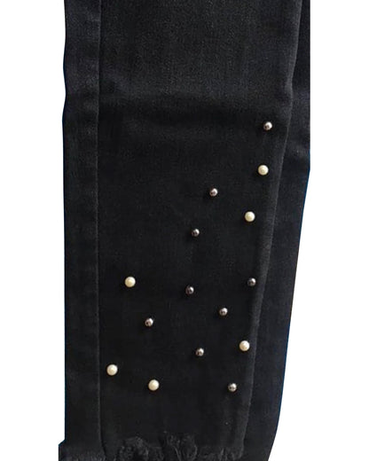 Black pants with pearl embellishments on a white background