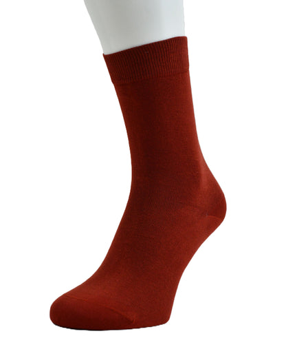 A single rust-red crew sock displayed on a white mannequin leg against a plain white background.