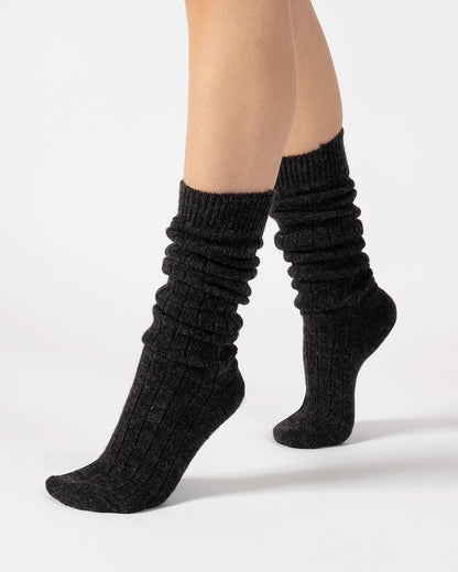Dark grey ribbed socks worn by a person on a white background