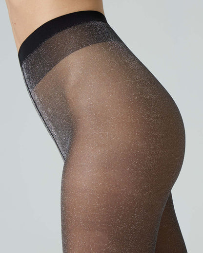 Sheer black tights with a silver glittery waistband on a grey background