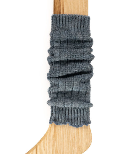 A pale denim blue chunky ribbed knitted leg warmer displayed on a wooden model.