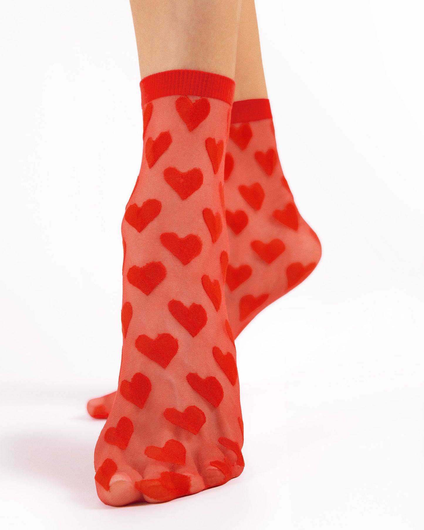 Sheer red fashion ankle socks with an opaque heart pattern.