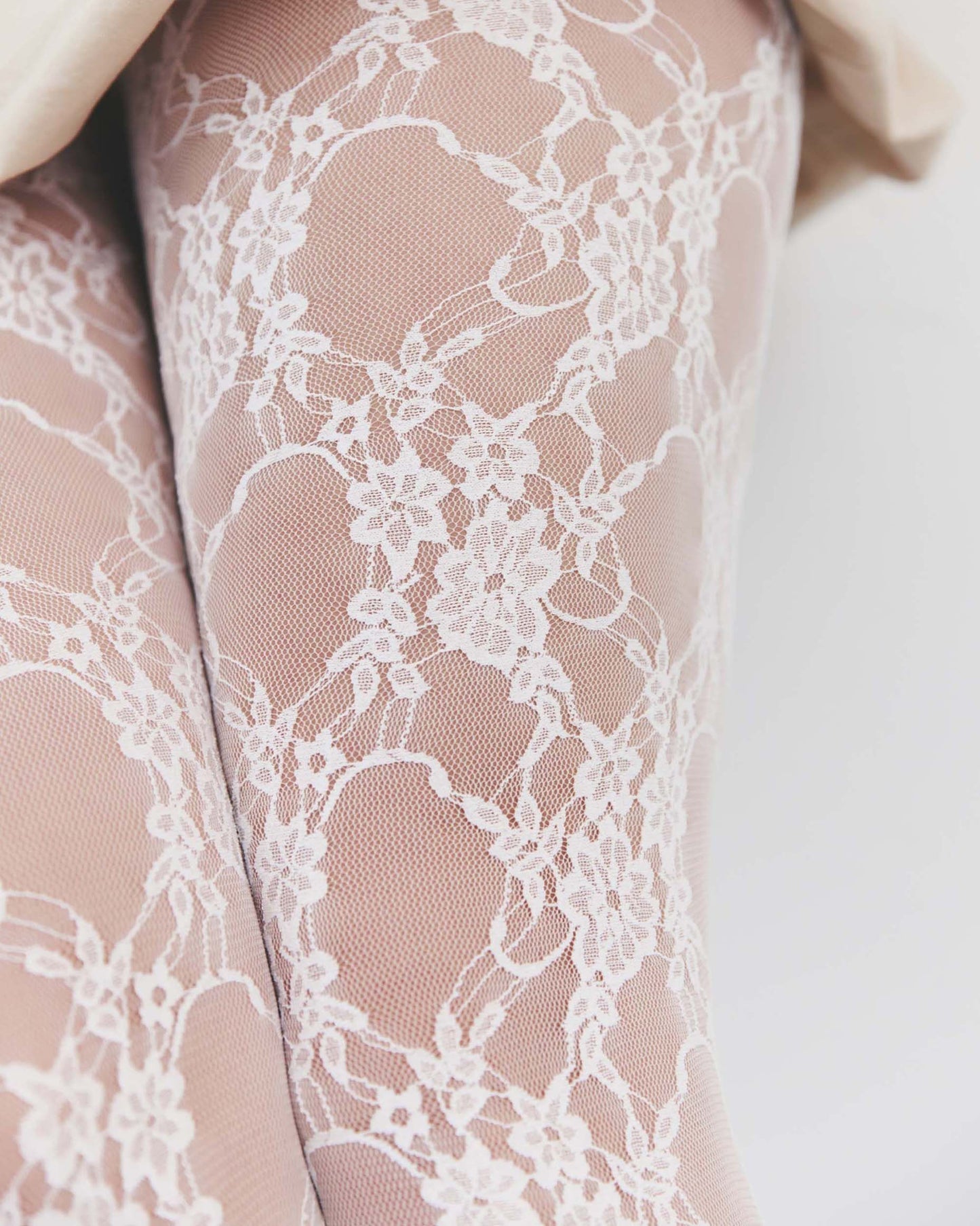 Fiore Donatella Tights - White floral lace tights on a micro mesh/tulle background with a back seam. Close up detail.