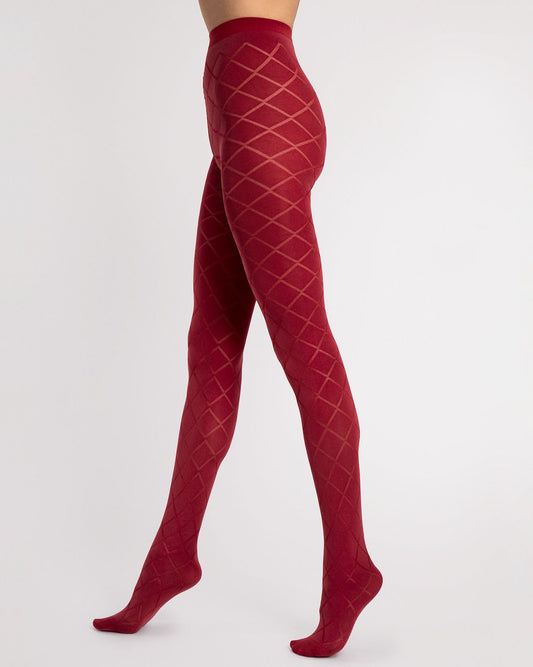Red tights with a diamond-patterned mesh design, shown on a model's legs against a light gray studio background.