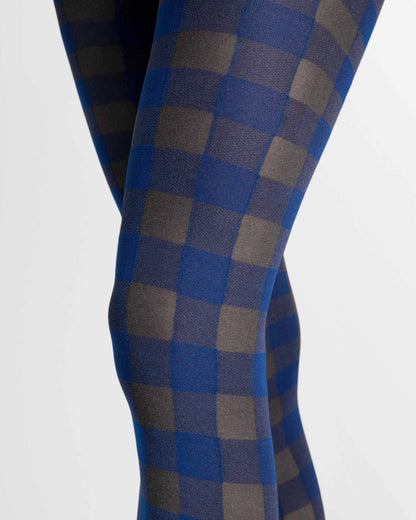 Close-up of a person's legs wearing blue and gray checkered tights against a plain light background.