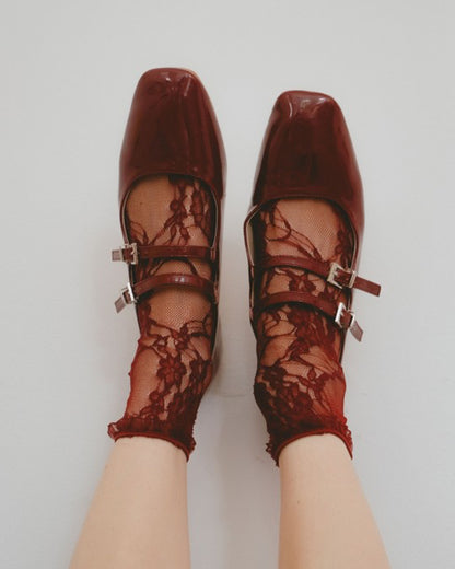 Burgundy red shoes with floral lace ankle socks on a white background