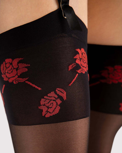 Black stockings with red rose pattern worn by a person.