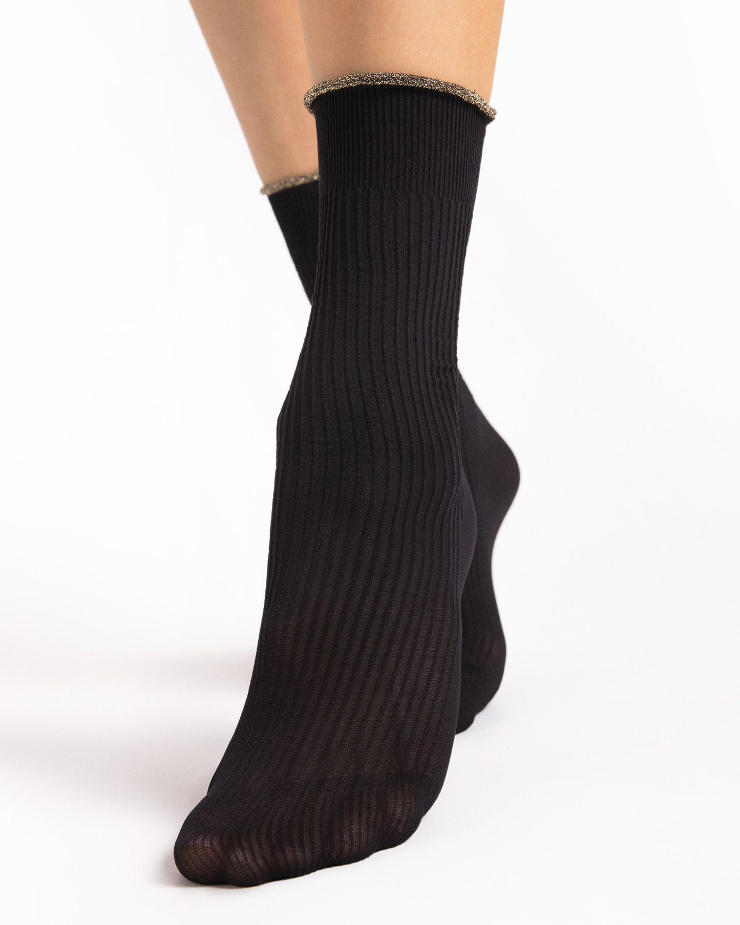 Black ribbed socks worn by a person on a white background