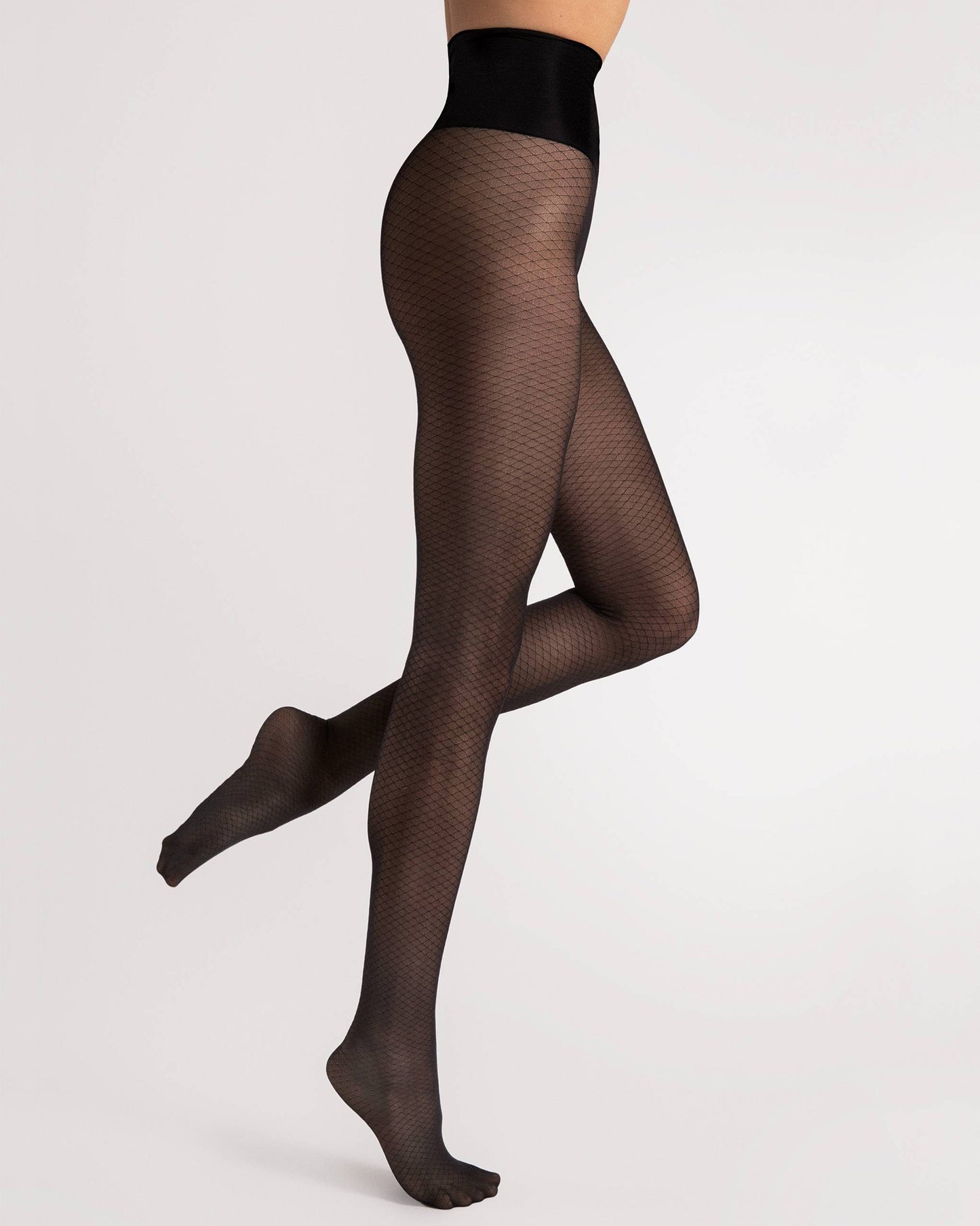 Black enclosed fishnet tights worn by a person on a light grey background