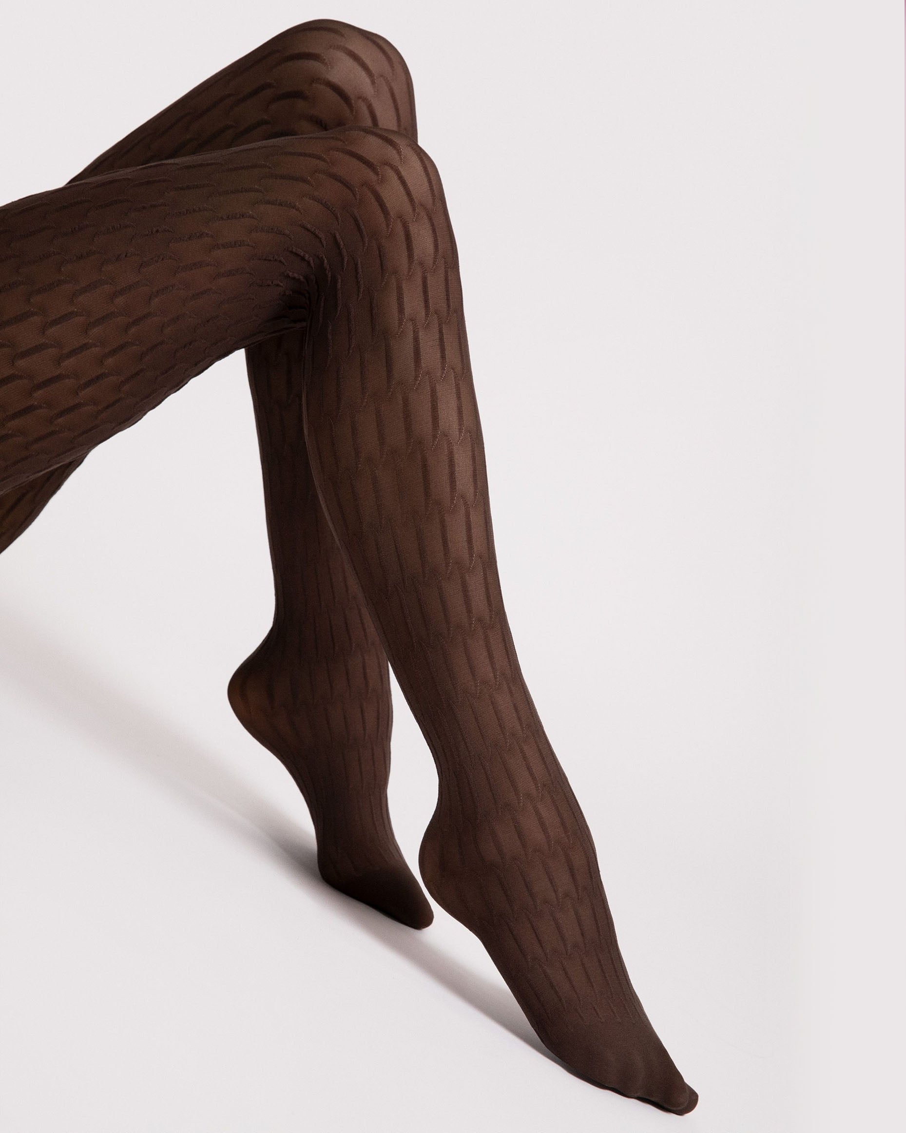 Brown textured tights worn by a person on a light grey background
