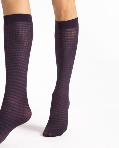Pair of dark purple patterned knee-high socks on a white background