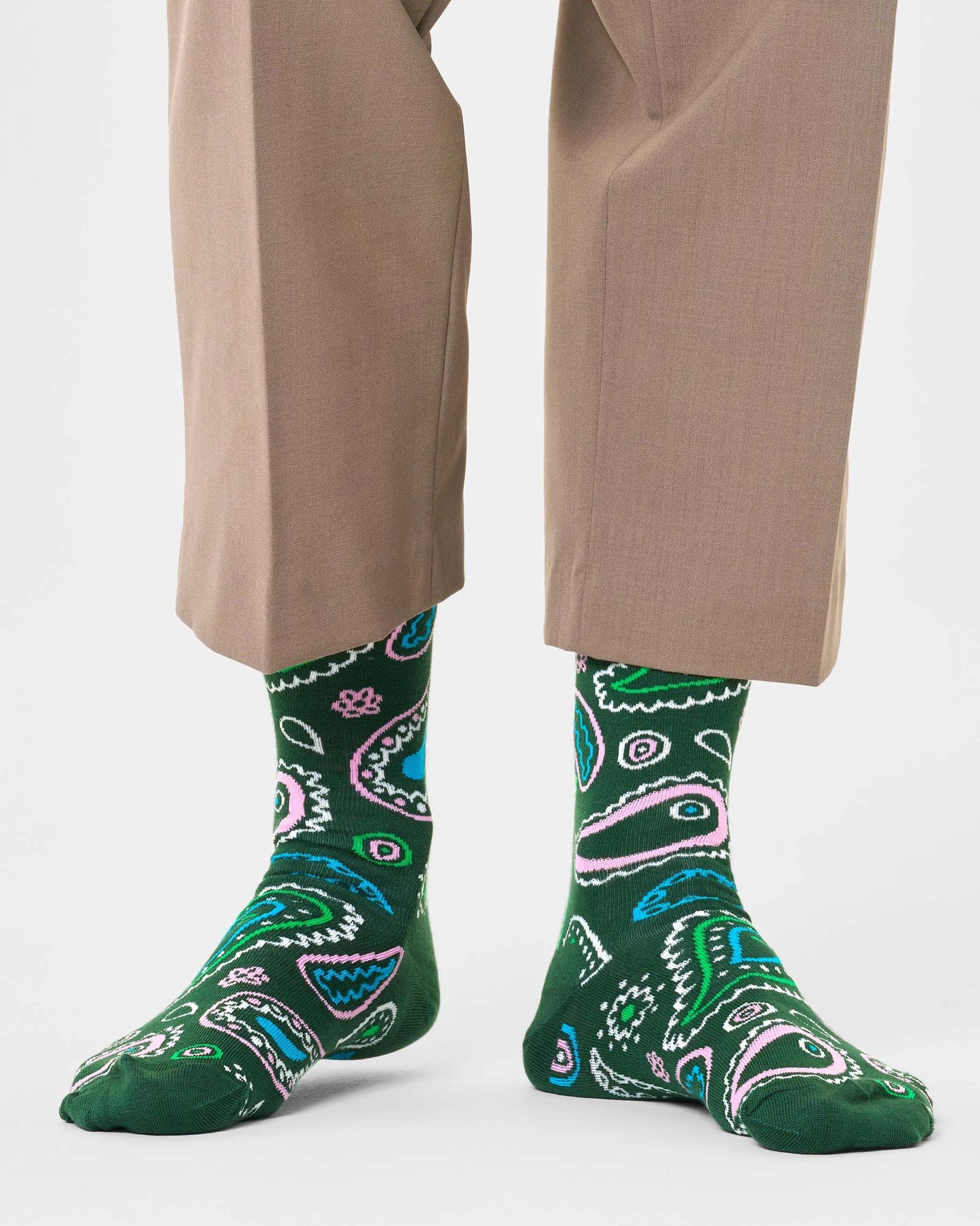 Happy Socks Paisley Sock - Khaki green cotton crew socks with a paisley style pattern in light shades of blue, pink, green and cream worn with cropped beige pants.