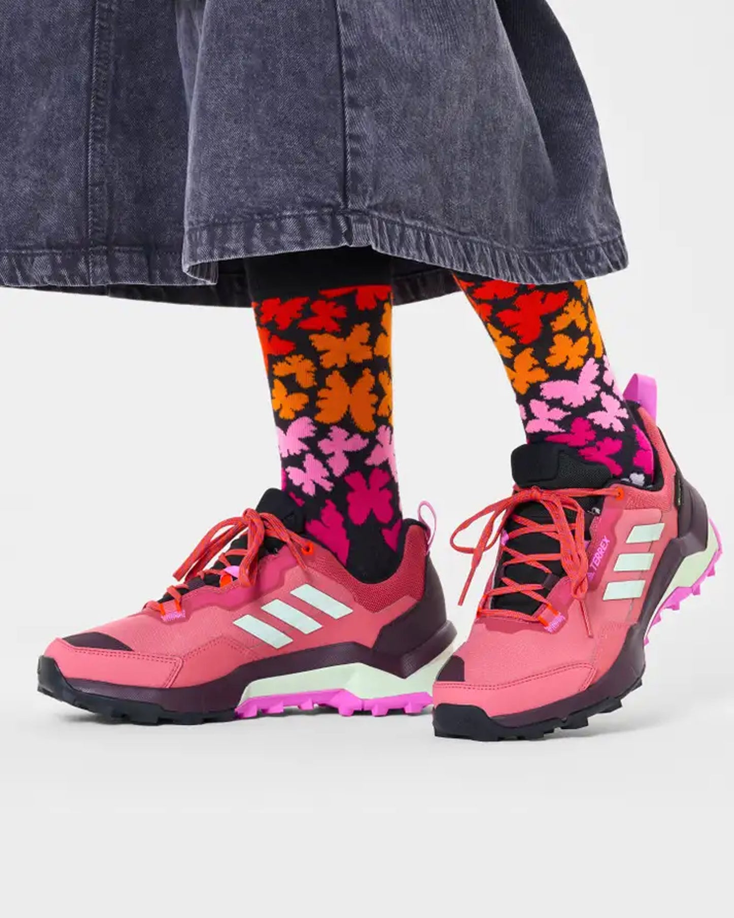 Happy Socks P000154 Butterfly Socks - Black crew length cotton socks with multicoloured butterfly pattern worn with trainers and cropped black jeans.