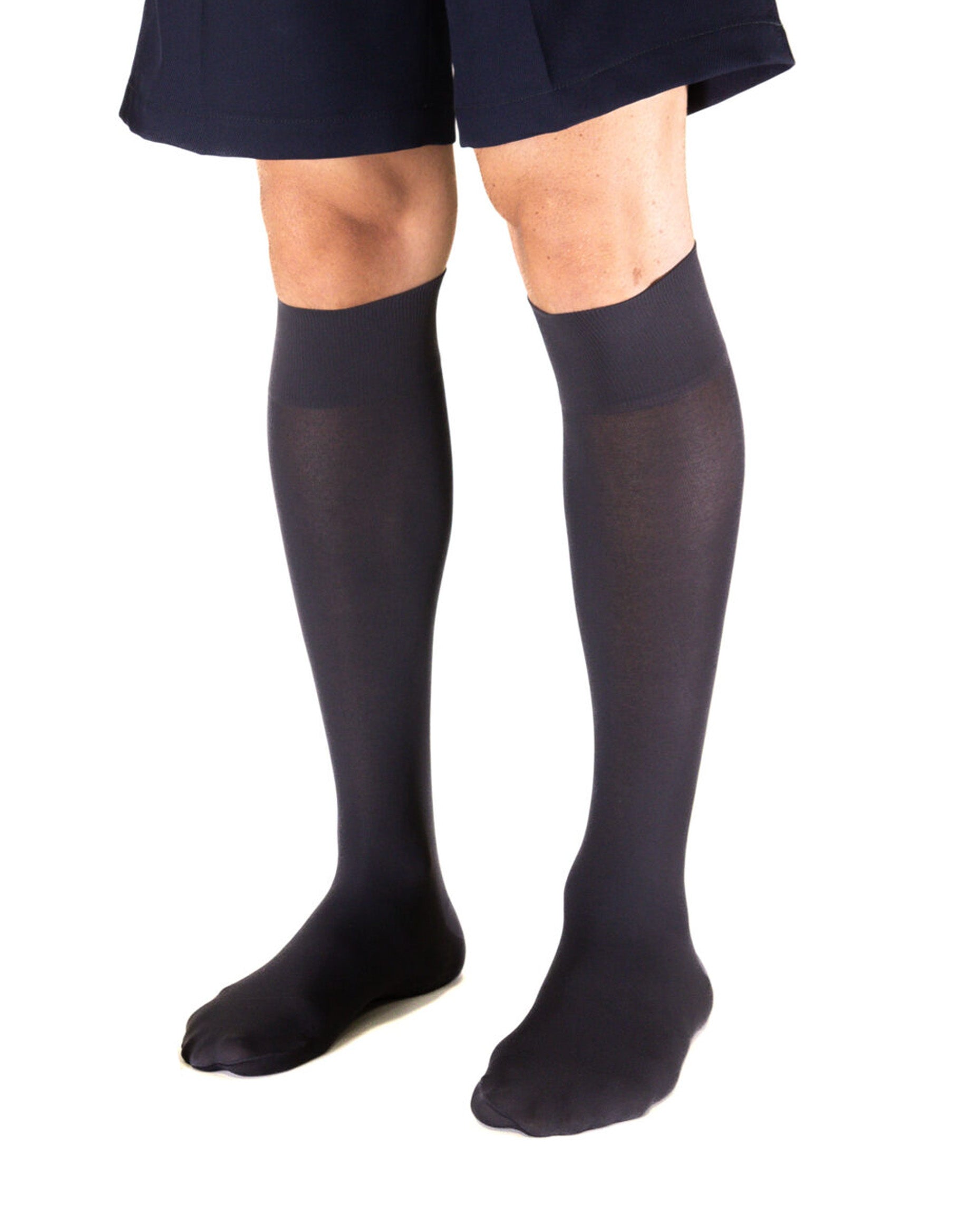 Man wearing navy knee-high socks and a navy shorts on a white background