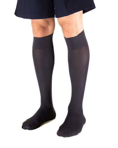 Man wearing navy knee-high socks and a navy shorts on a white background