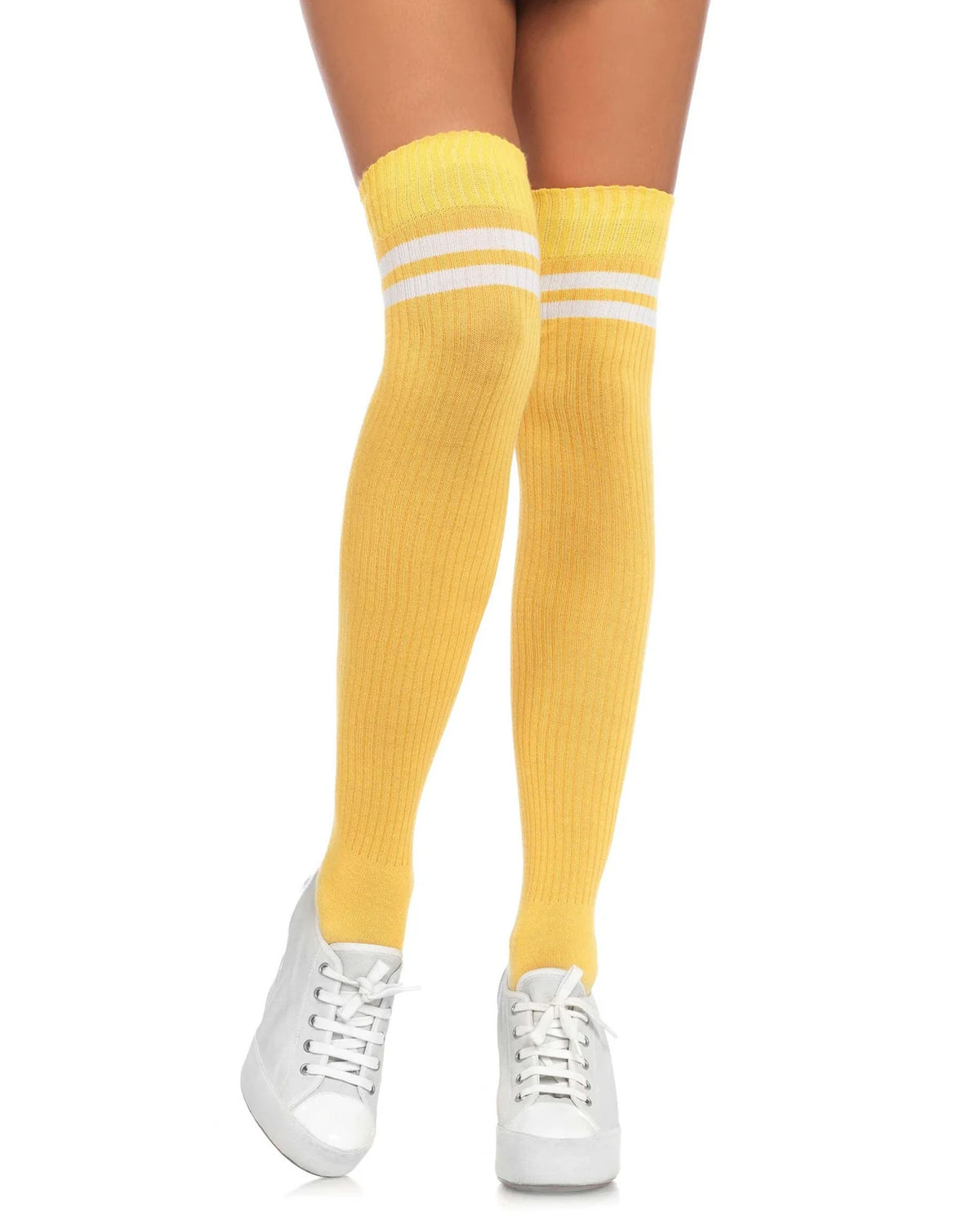 A person's legs wearing bright yellow ribbed over-the-knee socks with two white stripes near the top, paired with white sneakers, on a solid white background.