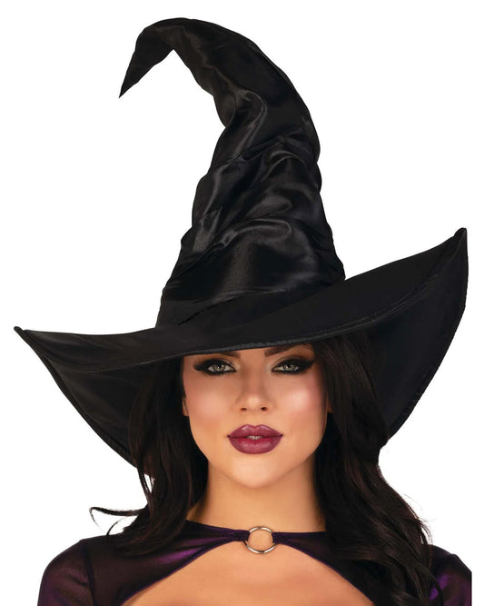 A woman wearing a tall black satin witch hat with a wide brim, shown against a plain white background.