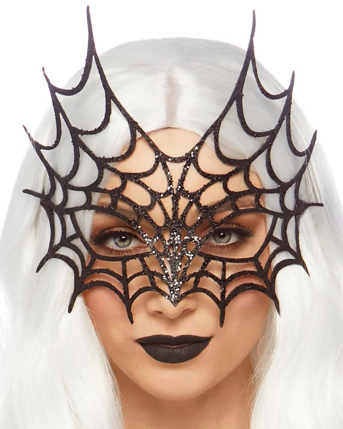 A close-up of a model with long white hair wearing a black spiderweb mask embellished with silver rhinestones, set against a plain white background.