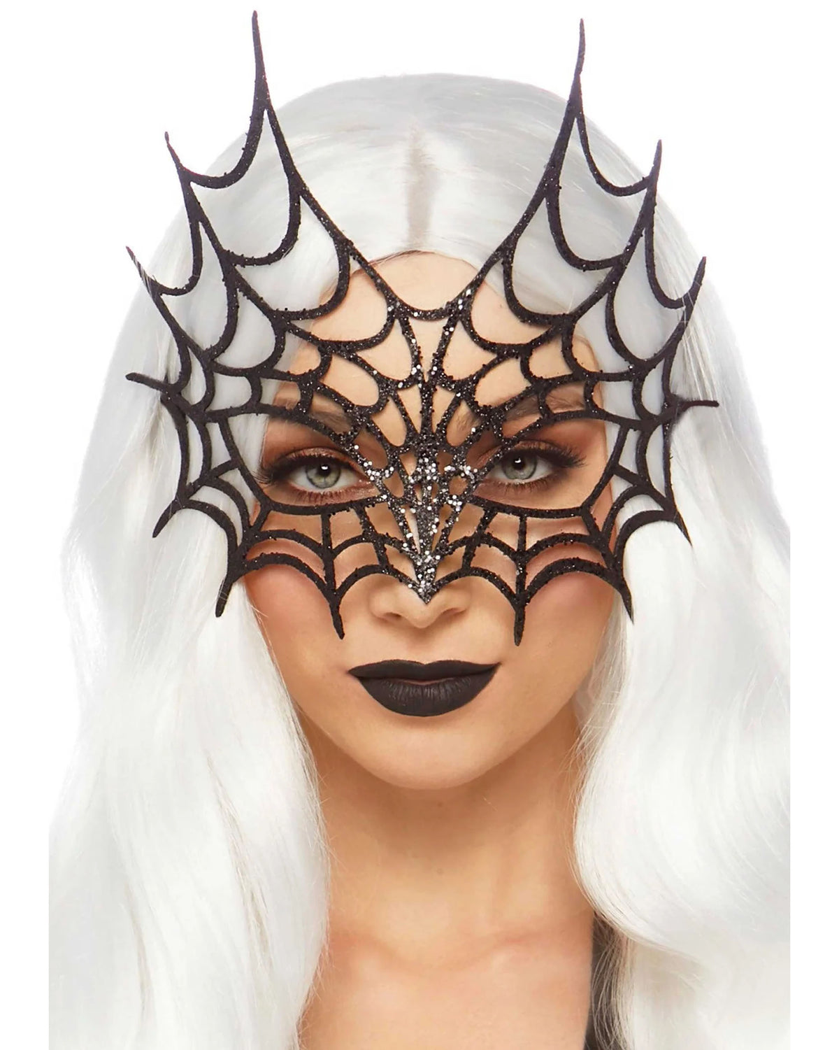 A woman with long white hair wearing a black spiderweb mask with rhinestone detailing, set against a plain white background.