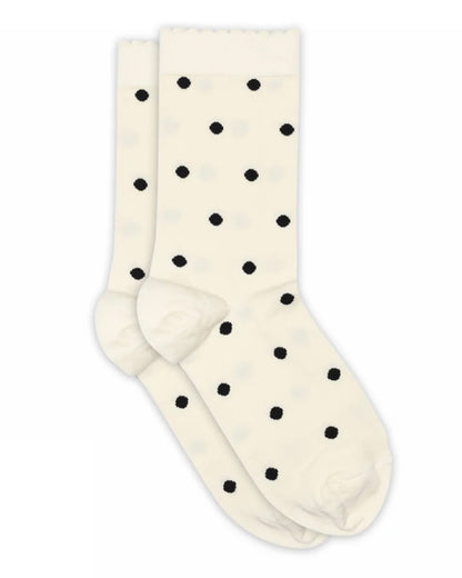 A pair of cream-colored crew socks with a black polka dot pattern, displayed against a solid white background.