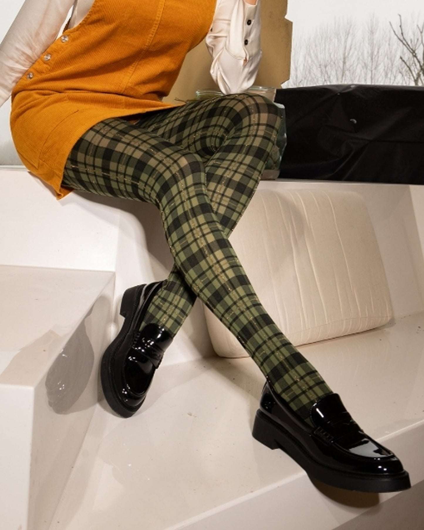 Olive green and black tartan patterned tights with gold stripe lurex, worn with black patent shoes and mustard dress.