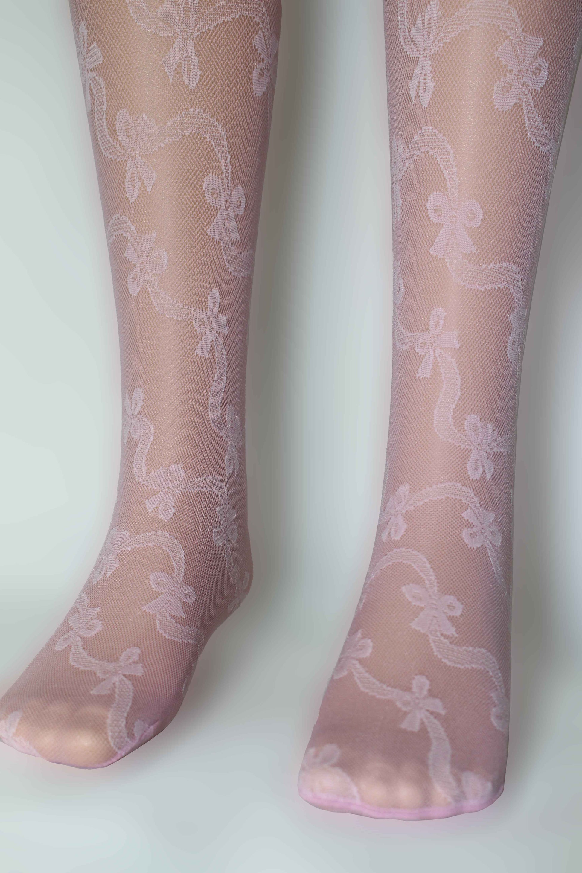 Omsa Serenella Gala Kid's tights - Light pale pink semi opaque micro mesh children's fashion tights with a woven ribbon and bow style pattern wrapping diagonally around the leg.