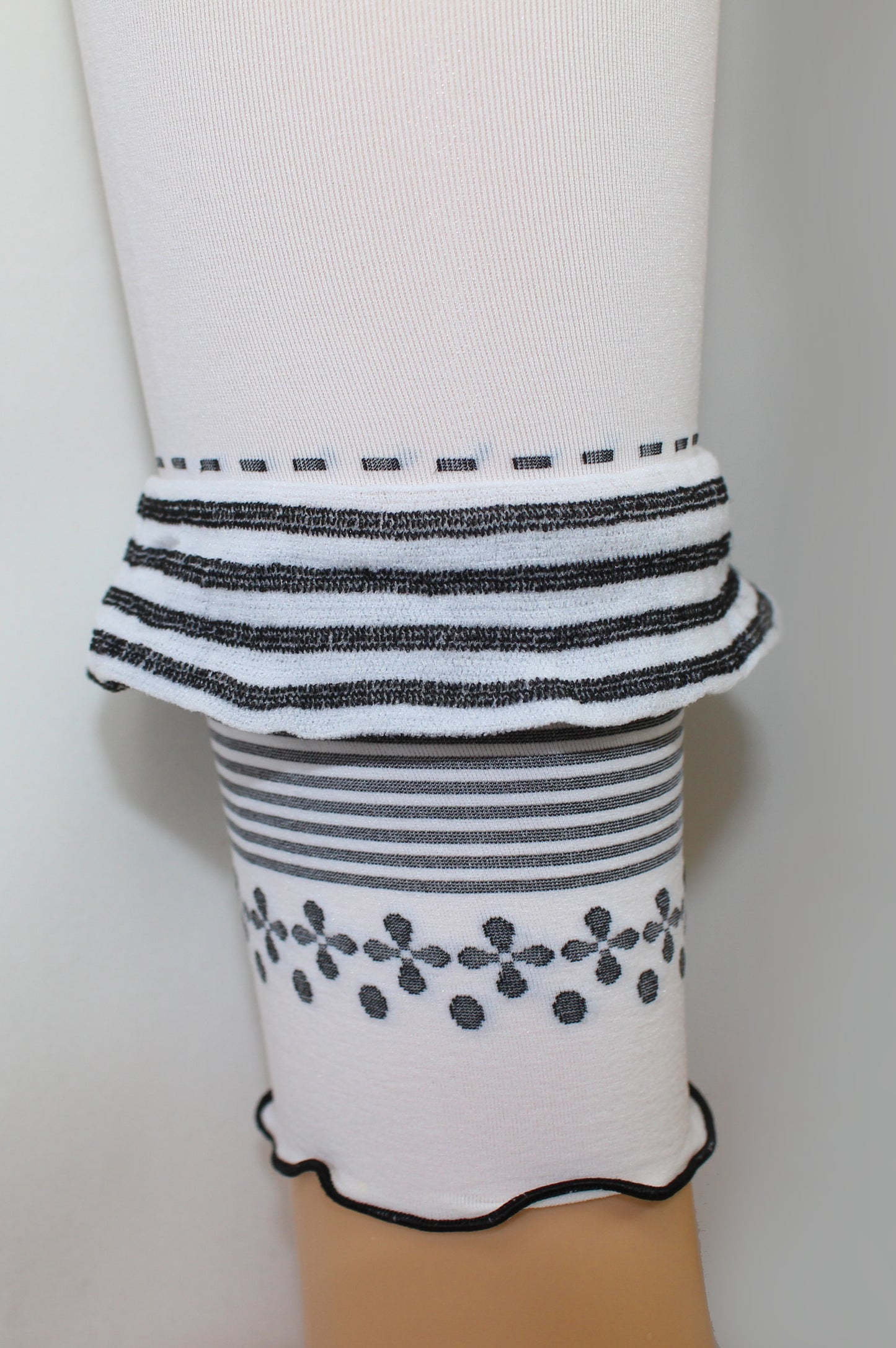 Omsa Outline Detail - Soft white opaque kid's footless tights leggings with a black horizontal striped ruched frill, striped and floral pattern edge.