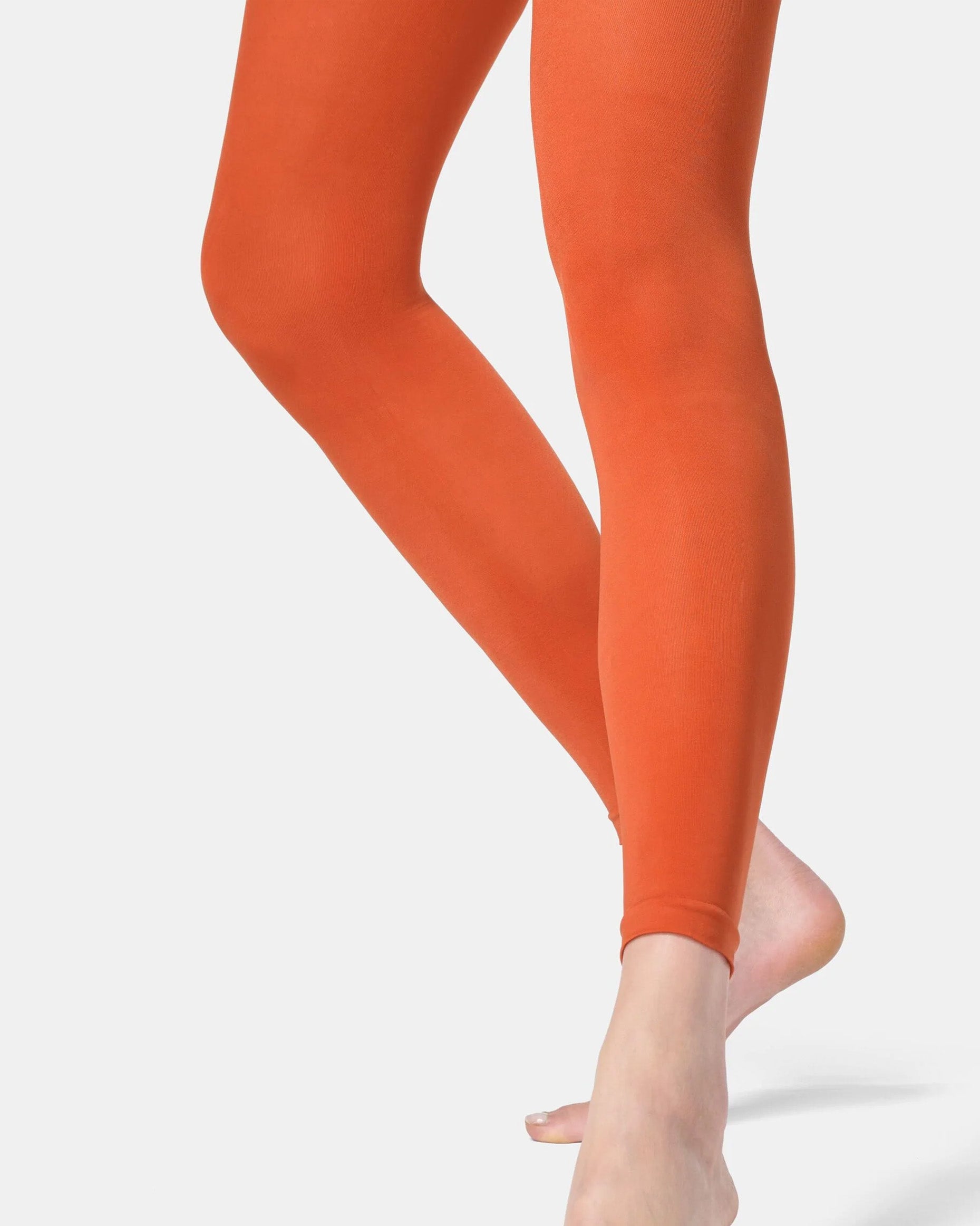 Orange leggings worn by a person on a white background