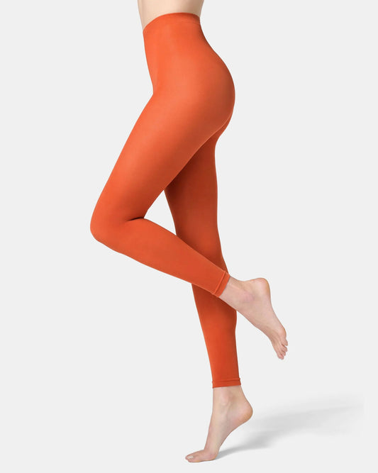 Orange leggings worn by a person on a white background