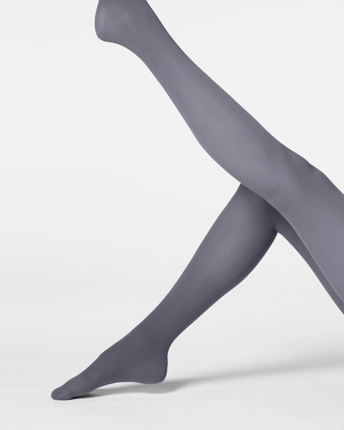 A pair of legs wearing smooth, semi-sheer gray tights, posed against a clean, light gray studio background.