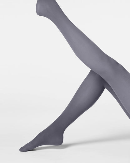 A pair of legs wearing smooth, semi-sheer gray tights, posed against a clean, light gray studio background.