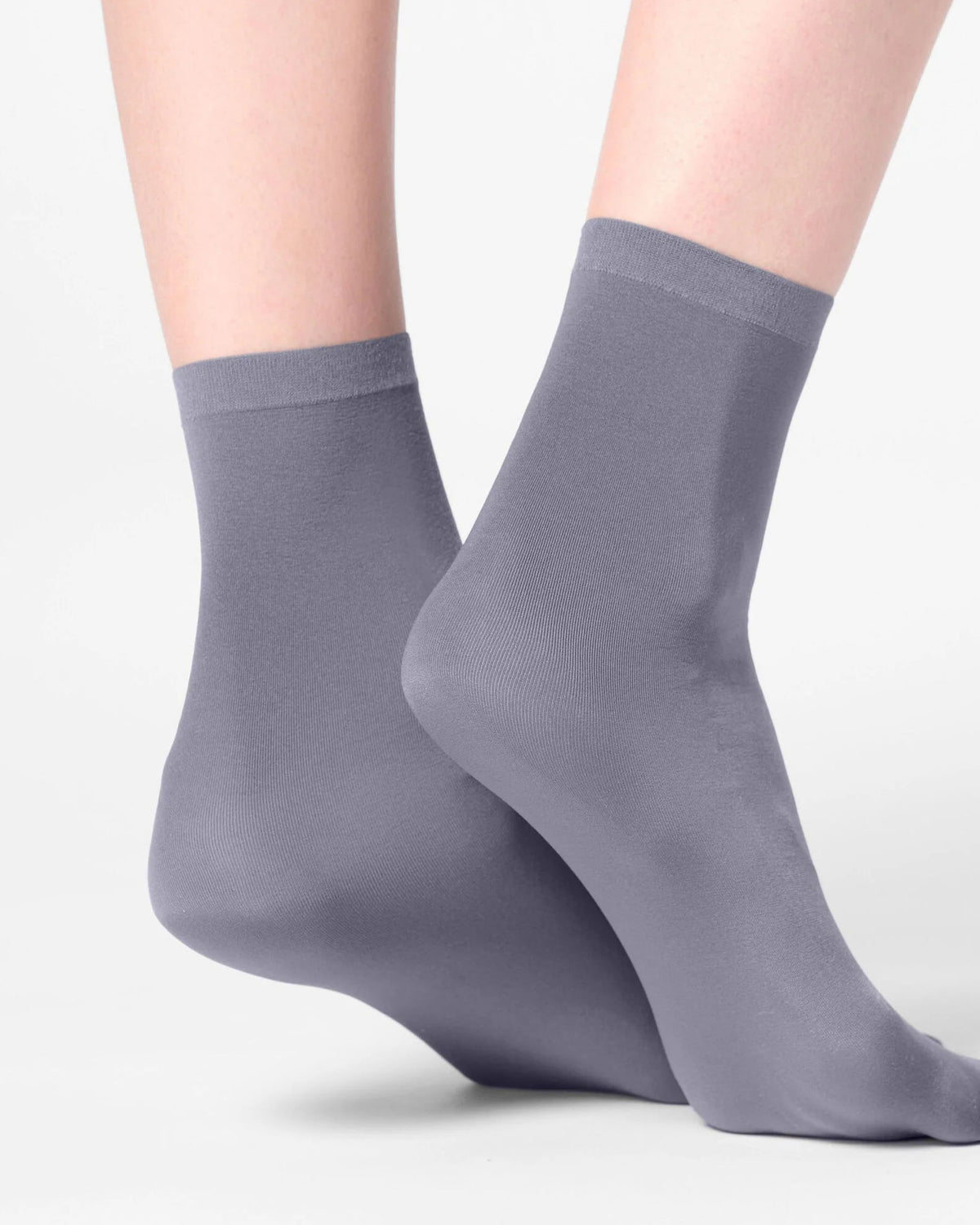 A pair of crew-length gray socks worn on feet, shown against a clean light gray studio background.