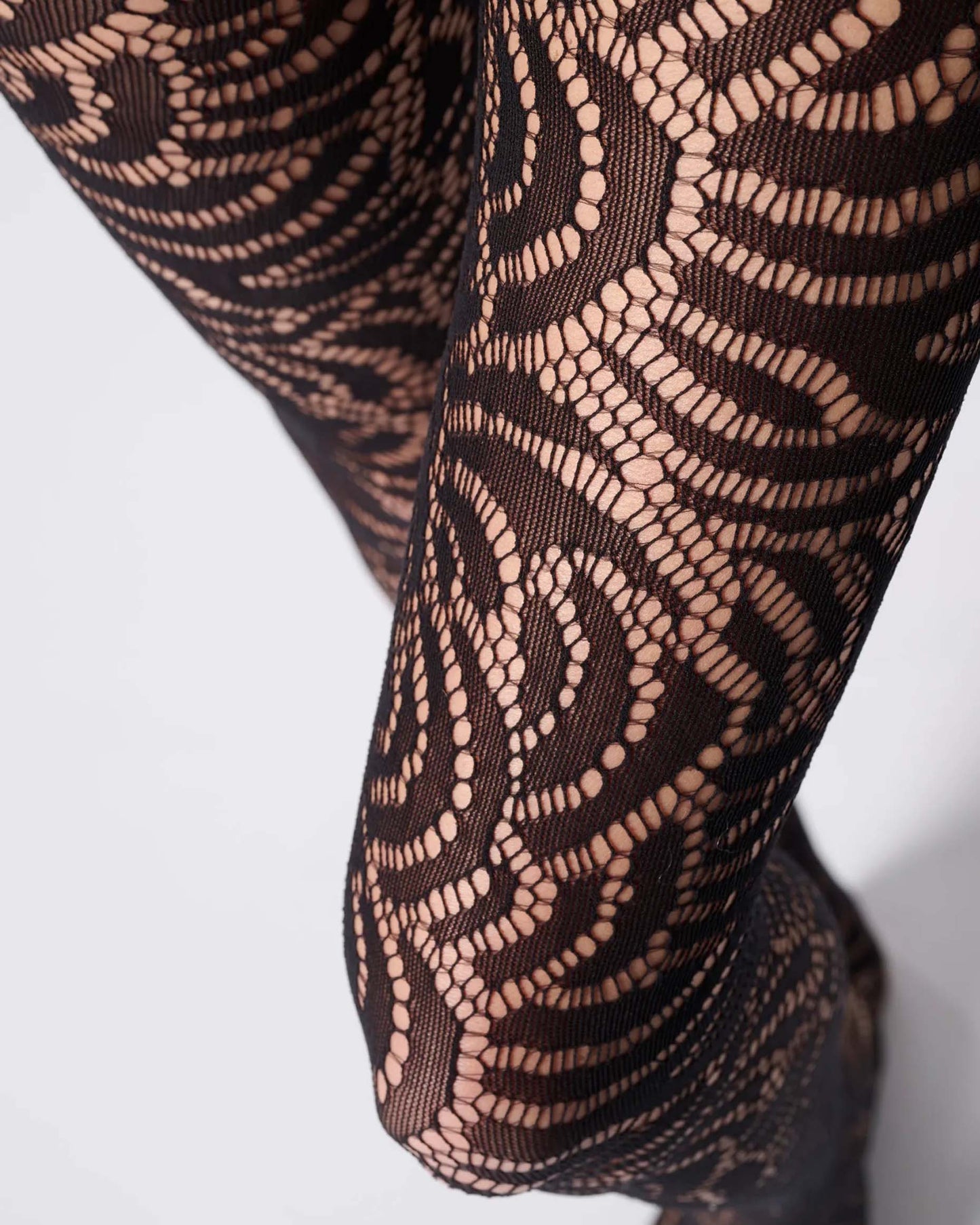 Soft black openwork floral lace style tights close up detail.