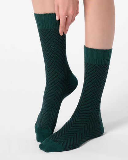 Dark green chunky knitted socks with a black zig-zag pattern