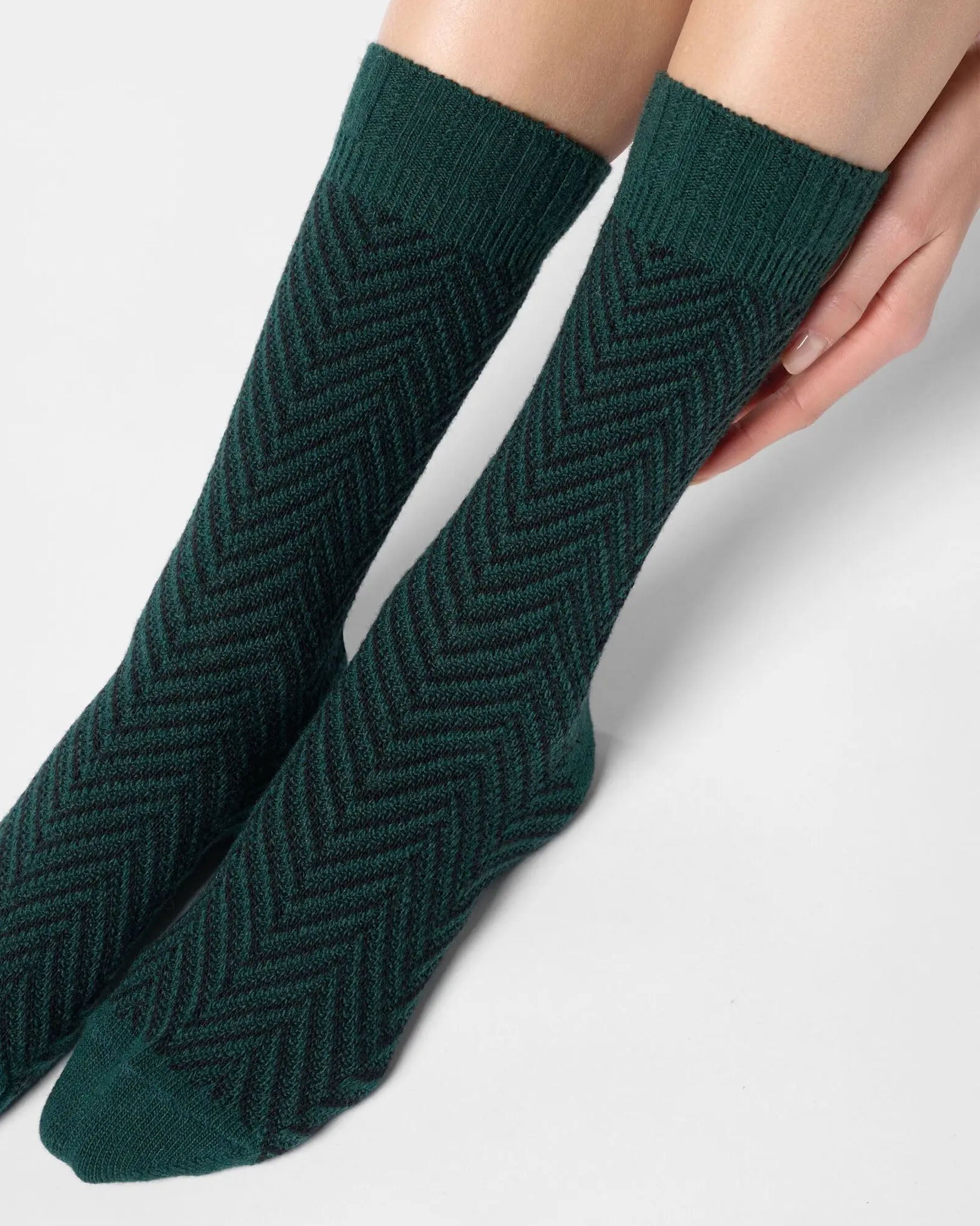 Dark green chunky knitted socks with a black zig-zag pattern