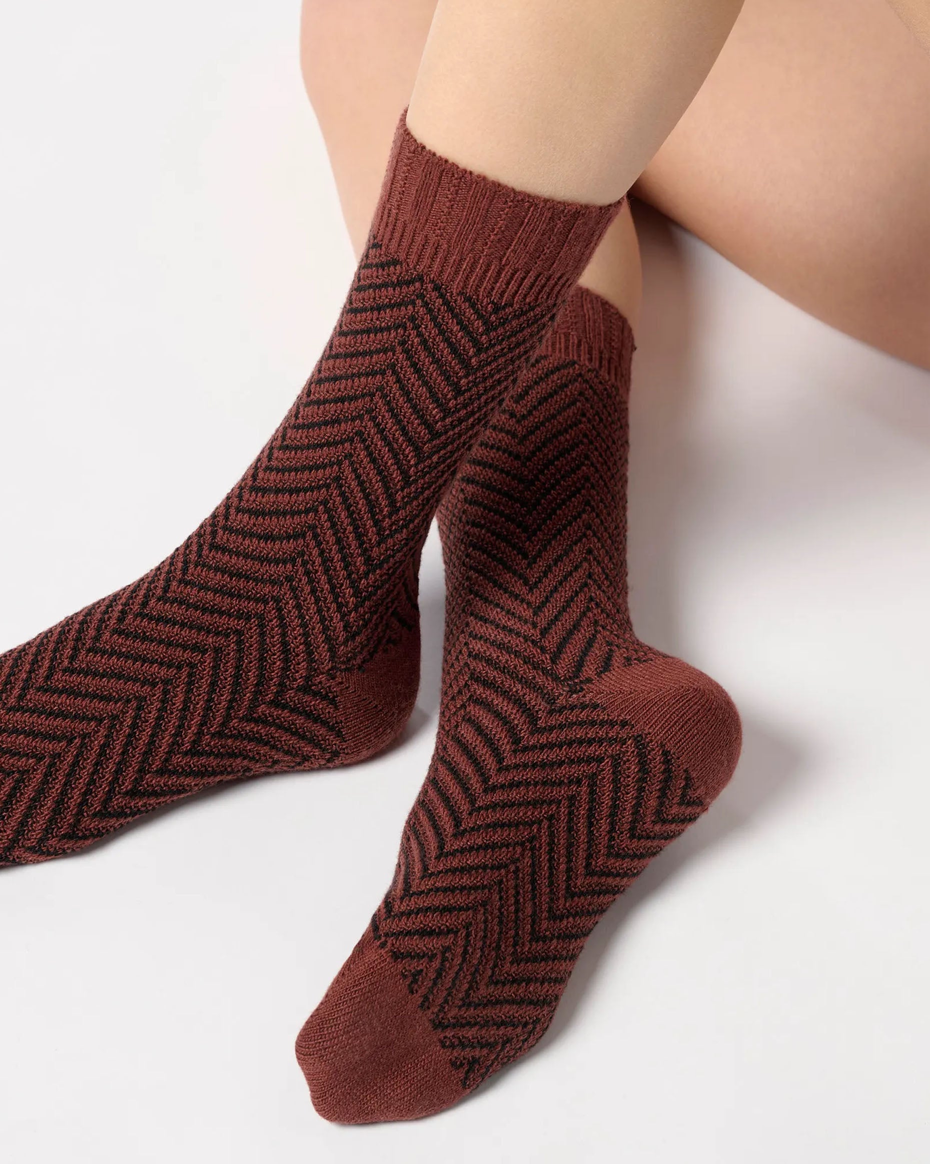 Brick red chunky knitted socks with a black zig-zag pattern