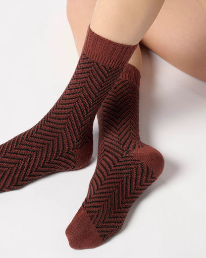 Brick red chunky knitted socks with a black zig-zag pattern