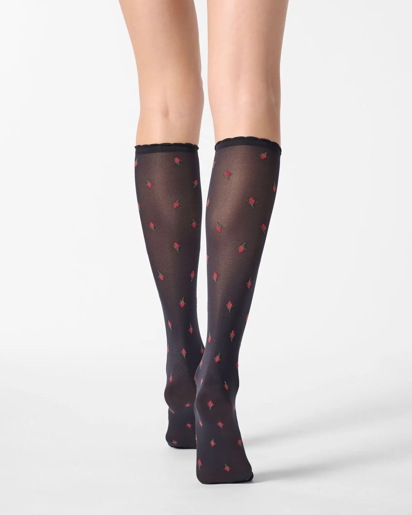 Black semi-opaque knee-high socks with red flower pattern. Back view.