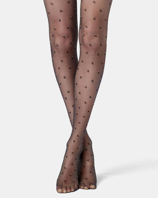 Sheer black tights with flower pattern worn by a person on a white background