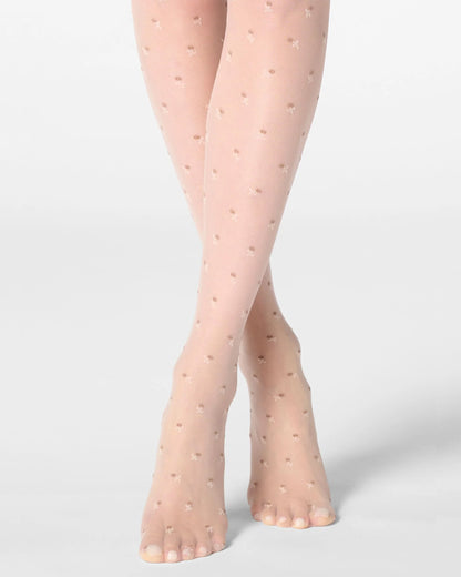 Sheer nude tights with small floral pattern worn by a person on a light grey background