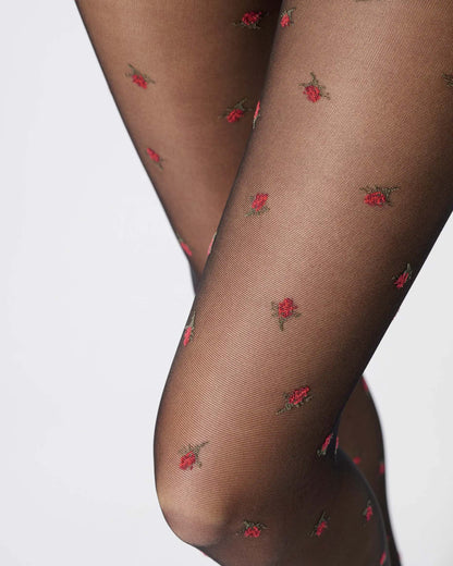Sheer black fashion tights with red roses pattern, close up detail.