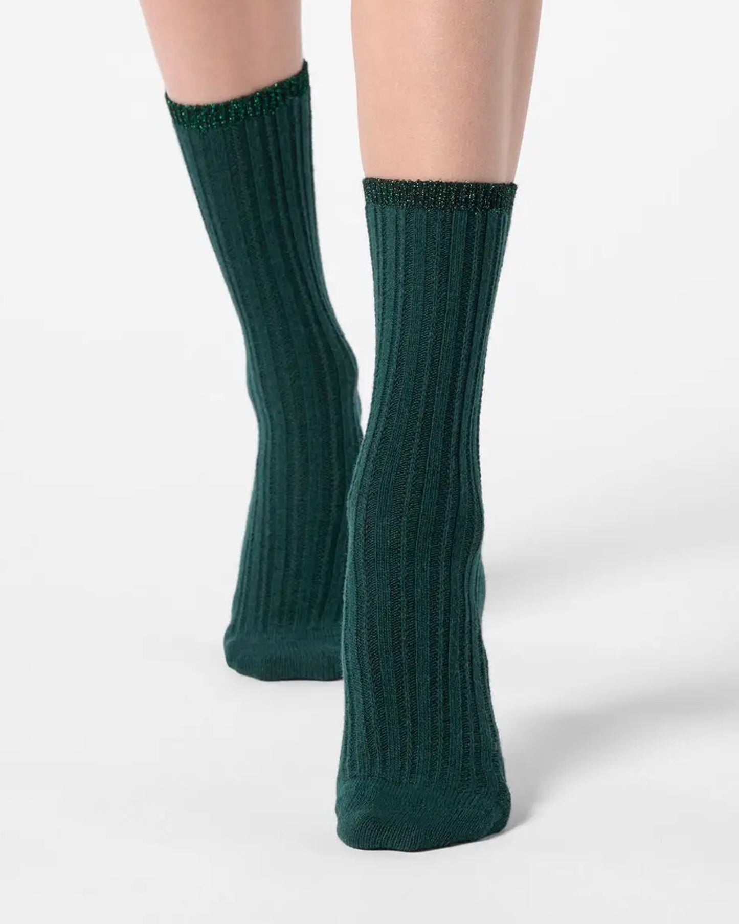 Green ribbed socks with sparkly lamé cuff worn by a person on a white background