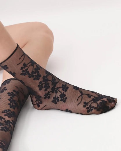 Oroblù Spring Flowers Sock - Sheer black fashion ankle socks with a woven floral pattern and no cuff roll top. Close up detail.