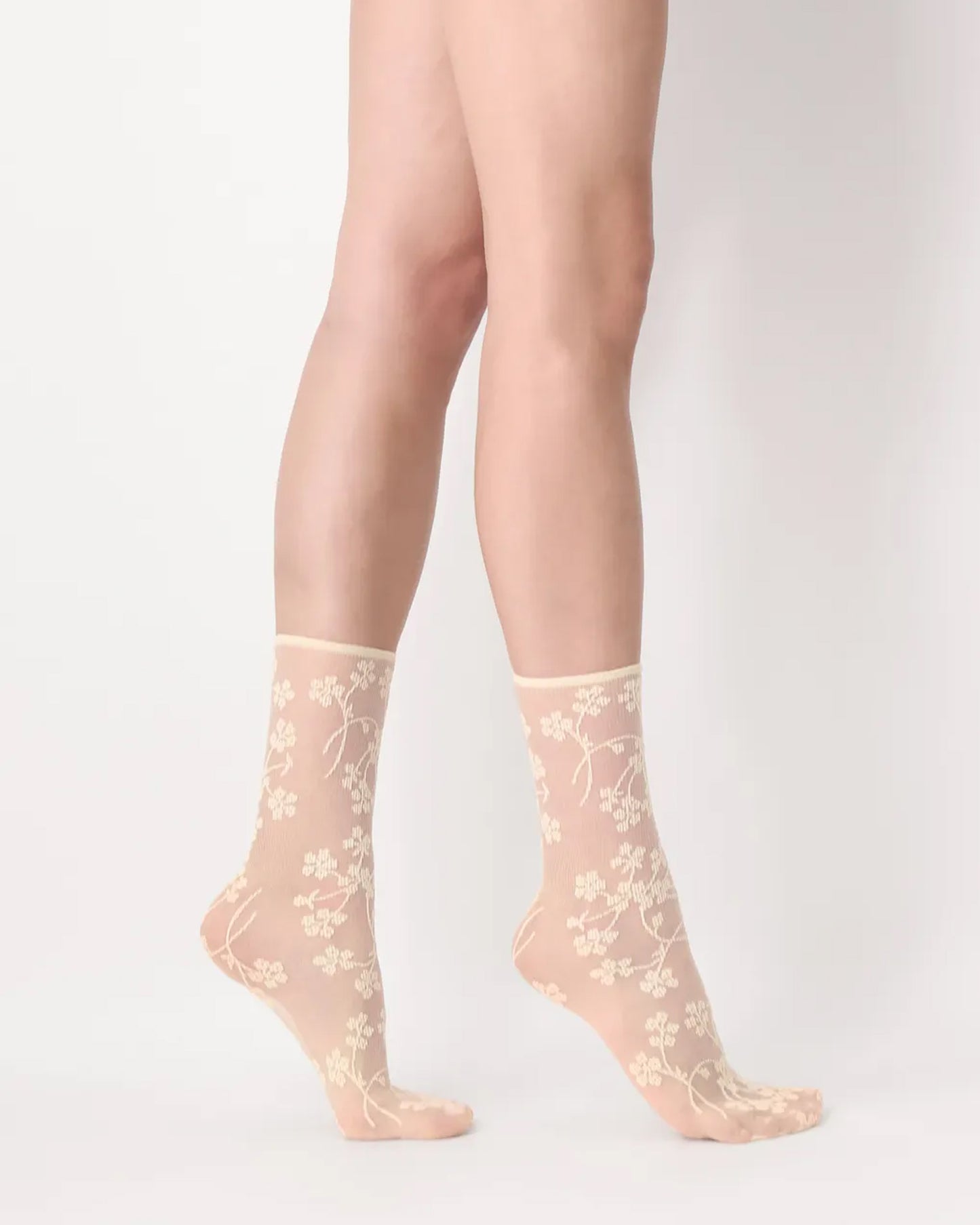 Oroblù Spring Flowers Sock - Sheer light pale yellow fashion ankle socks with a woven floral pattern and no cuff roll top. Side view.