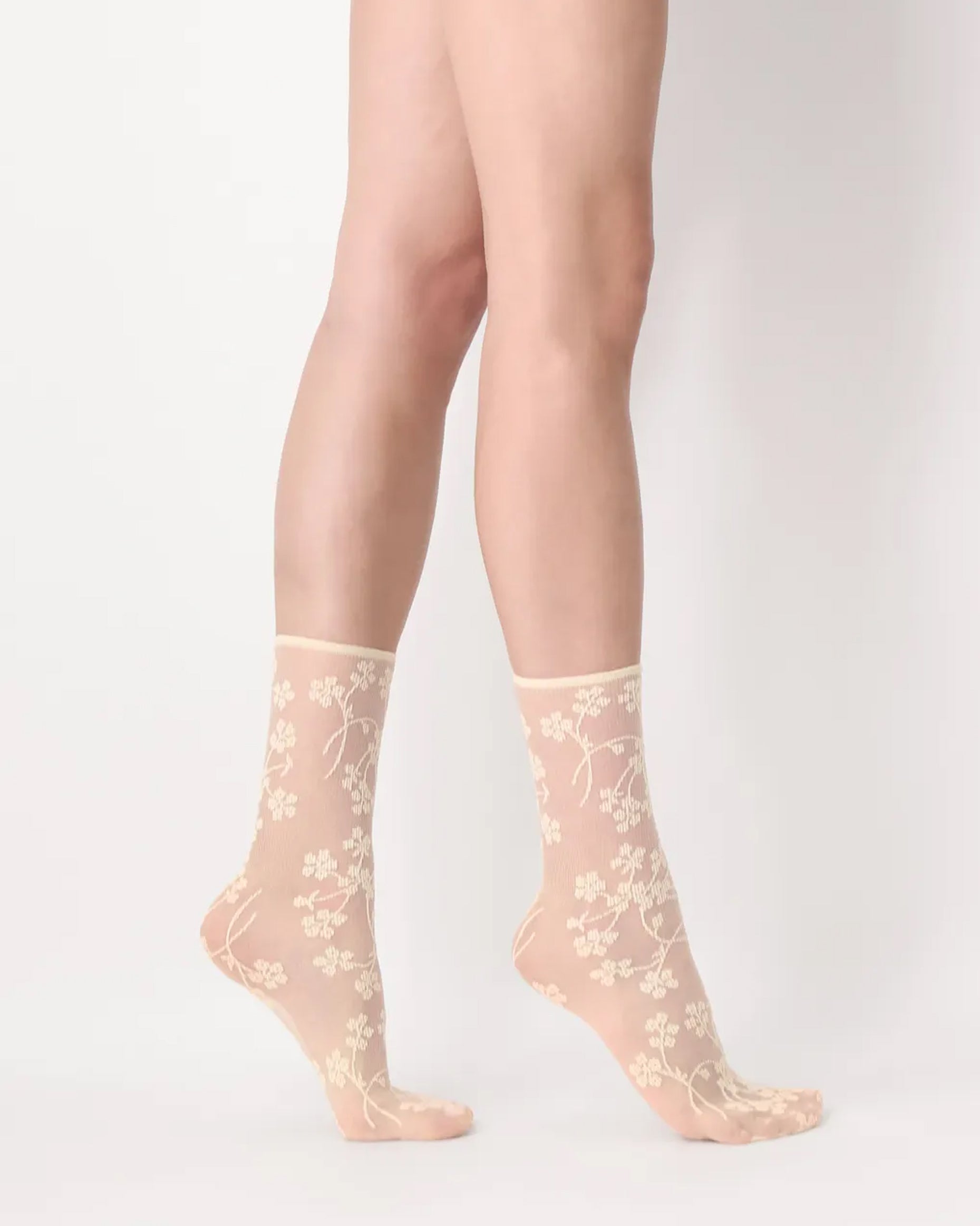 Oroblù Spring Flowers Sock - Sheer light pale yellow fashion ankle socks with a woven floral pattern and no cuff roll top. Side view.
